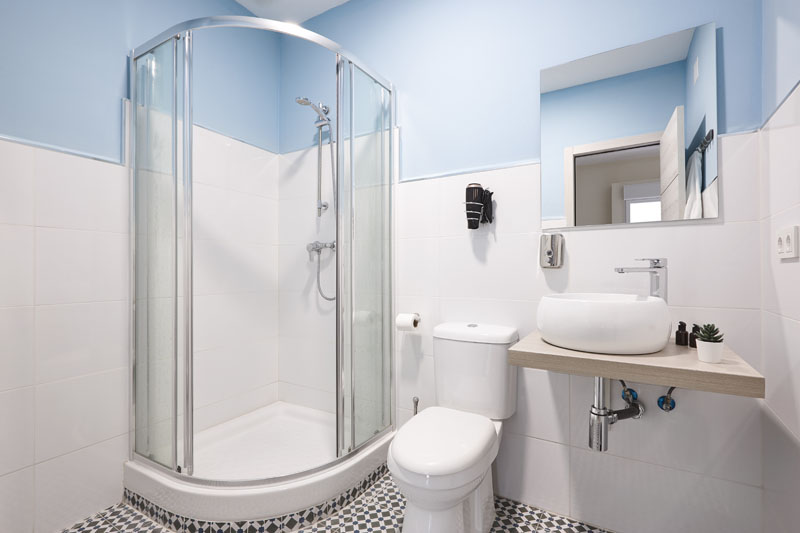 Bathroom with shower cabin, sink and basin. Hotel indoor Solar Leads process