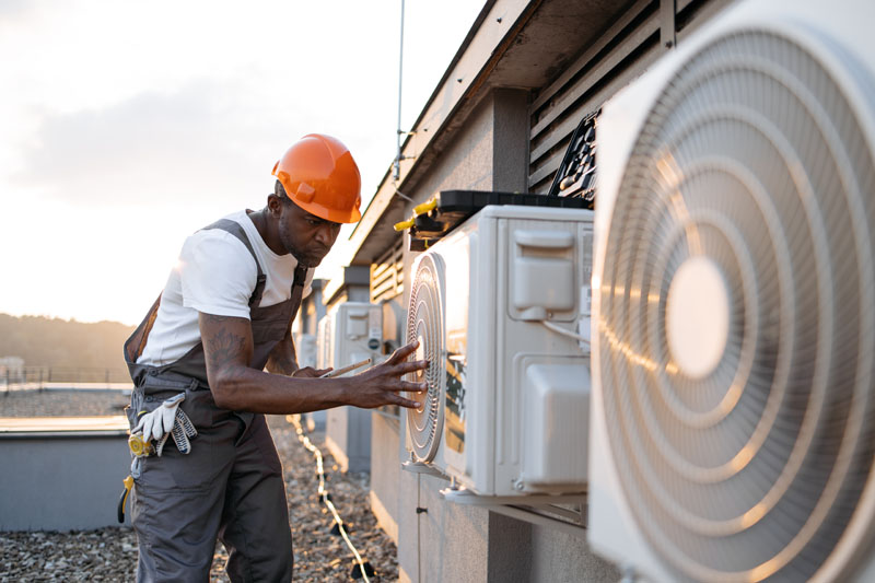 Male holding tablet and installing cooling system outdoors Investing in Solar Leads